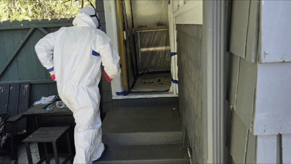All Track Exterminators technician entering a protected work area during an attic cleanout.
