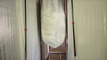 Protective containment installed around a pull-down attic staircase during an attic cleanout project